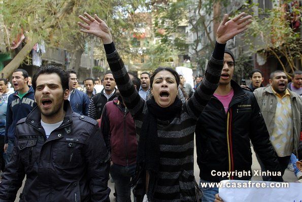Protesters in Egypt, woman with arms raised yelling
