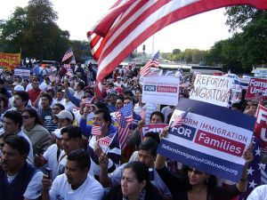 crowd of people at a rally, one prominent sign says reform immigration for families