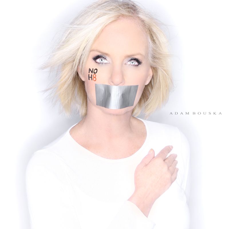Cindy McCain posing with tape over her mouth and NOH8 written on her face