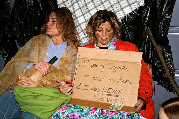 Photo of two women dressed as drunk homeless people