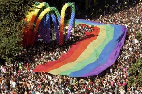 rainbow banner and large crowd of people