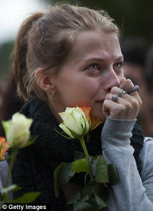 a young girl mourns in Norway after the deadly shooting
