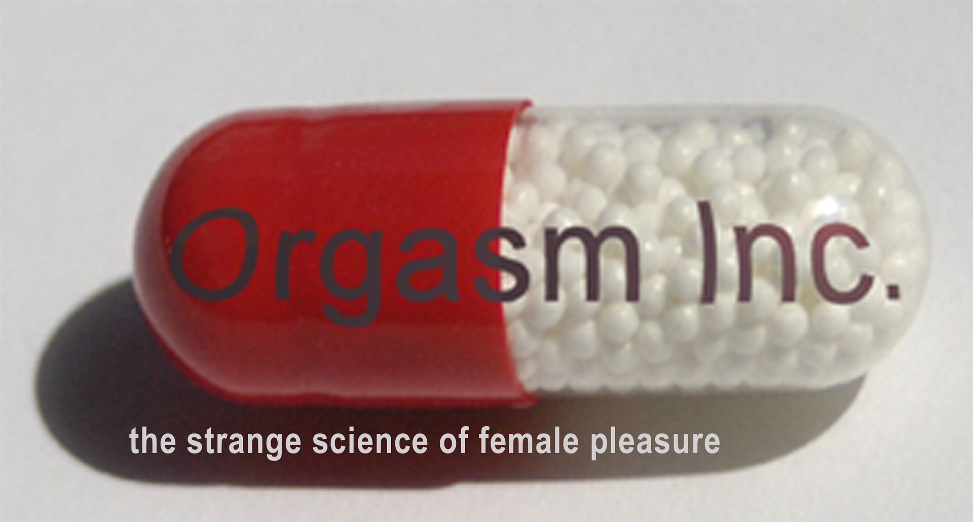 Large pill with the words Orgasm Inc written over. Tag line: The strange science of female pleasure
