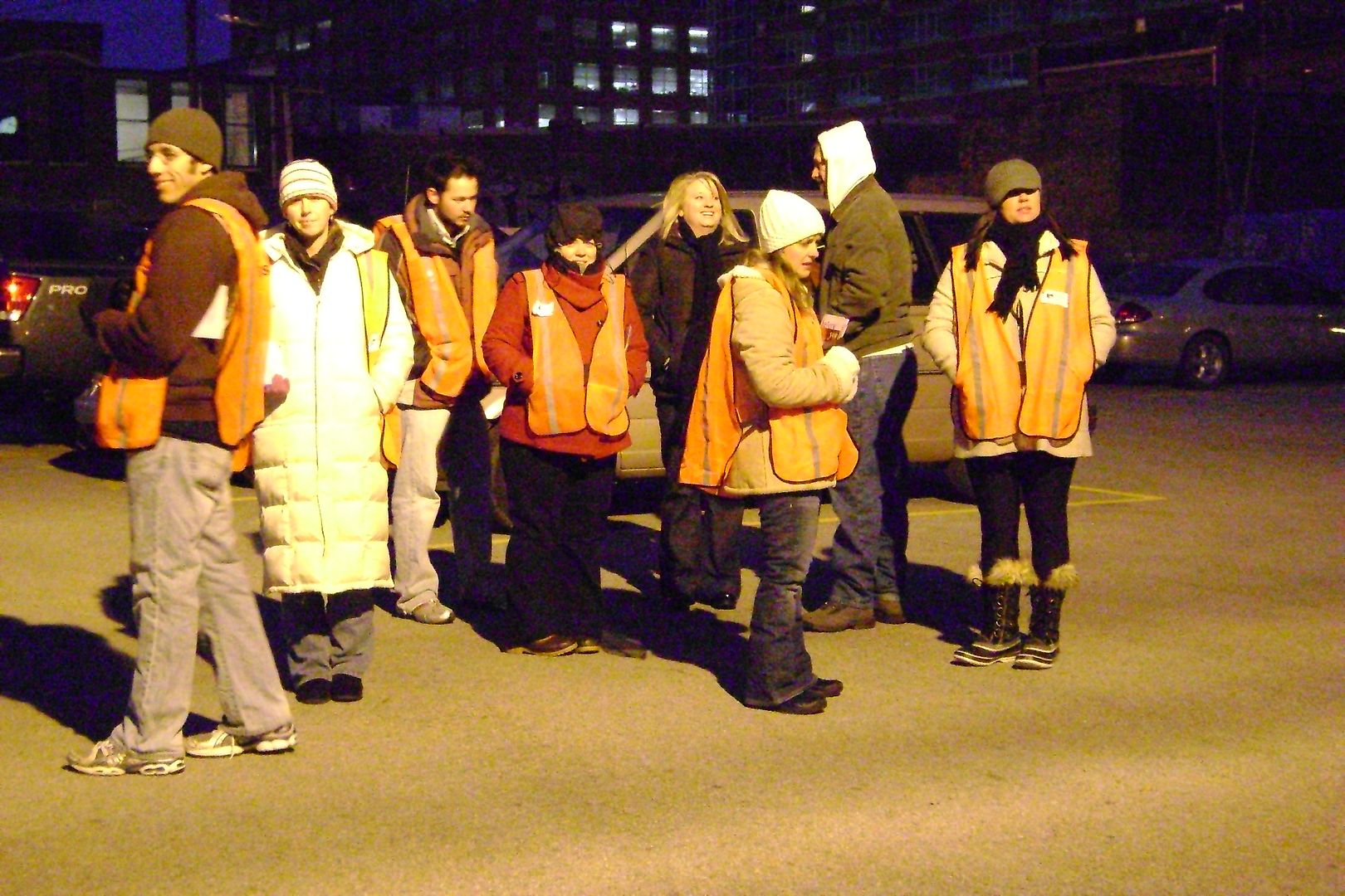 Antis standing outside a clinic wearing orange vests that make them look just look pro-choice clinic escorts