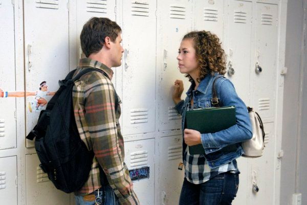 Luke and Becky from Friday Night Lights talk in front of a row of lockers at school