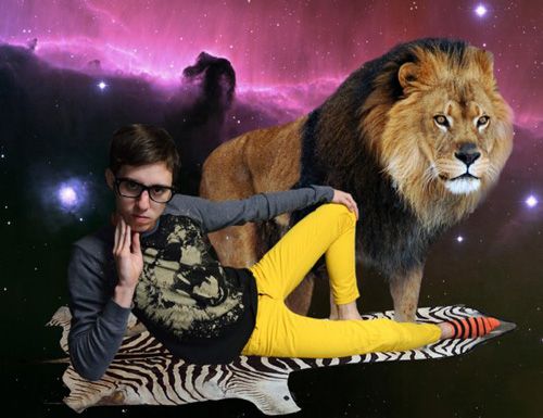 Hipster-y looking young man poses in front of picture of lion