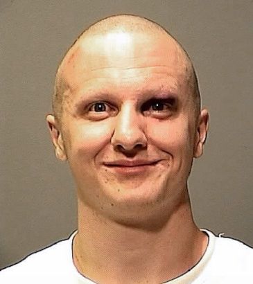 Jared Loughner, smiling with shaved head and black eye