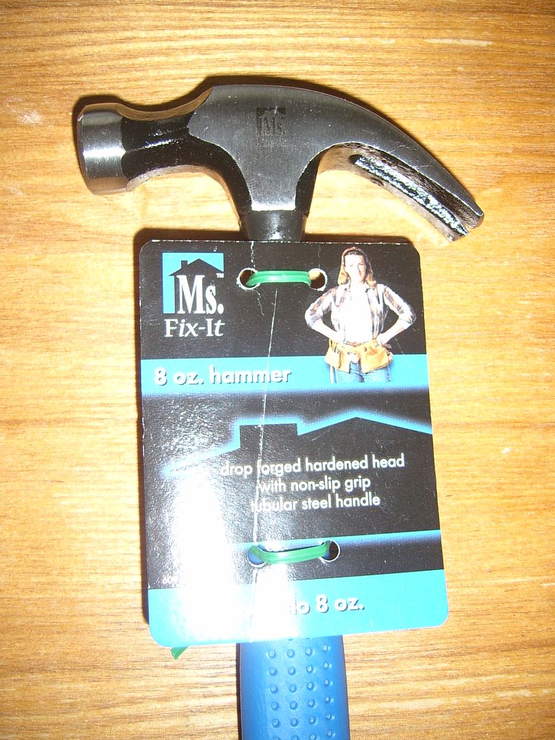 hammer with blue handle and a cardboard tag with a picture of Ms.Fix-It