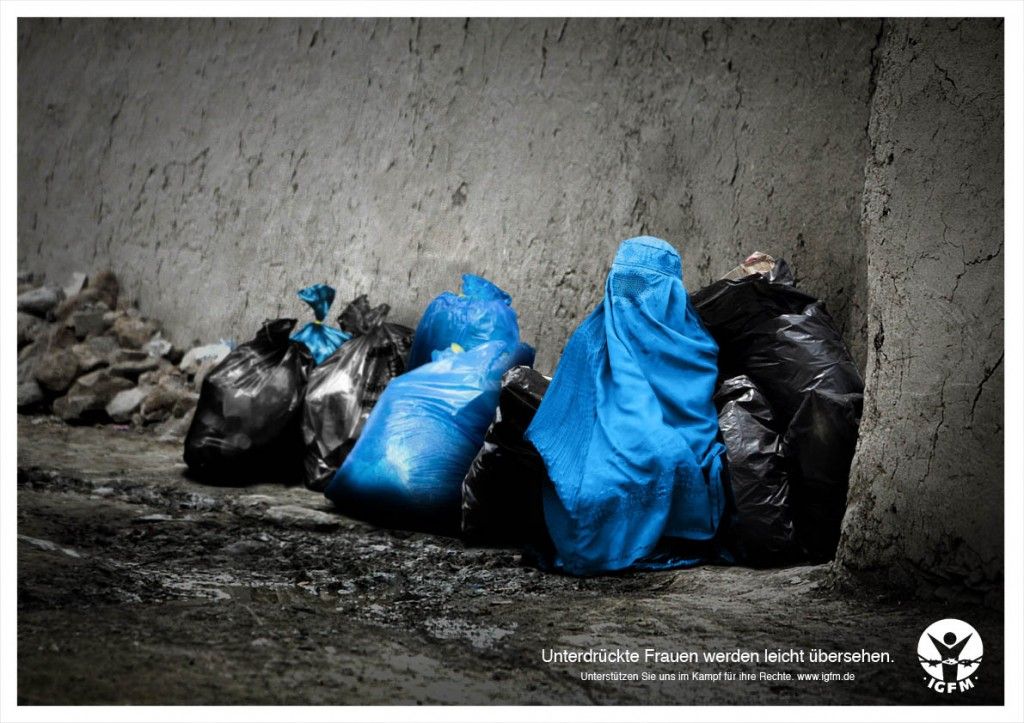 Poster showing a woman in a burqa among trash bags
