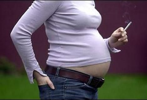 Midsection of pregnant woman smoking