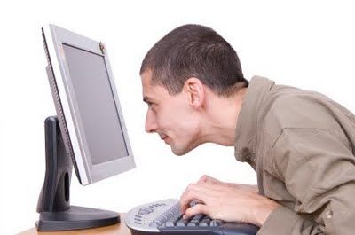 white man staring intently at computer screen, alone